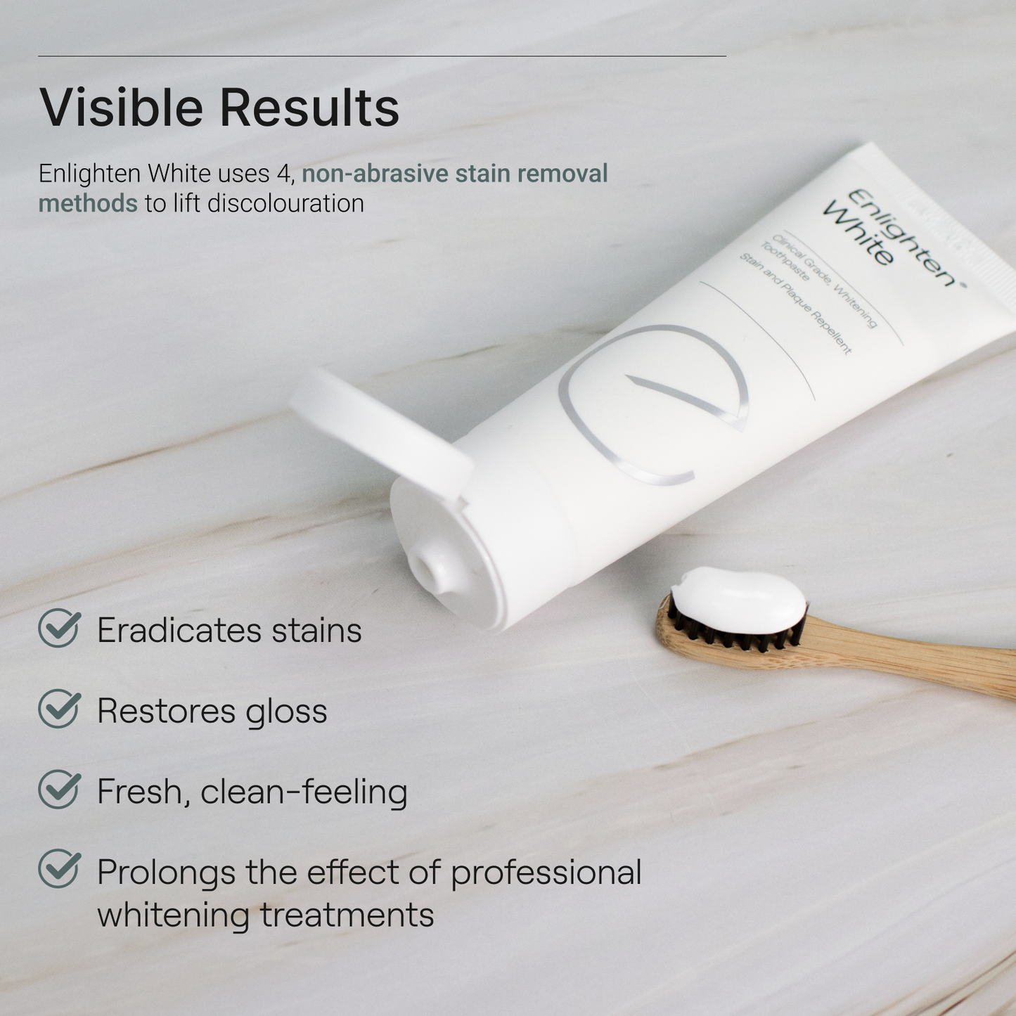 Enlighten White tube on marble surface with toothbrush, highlighting stain removal, gloss restoration, and prolonged whitening benefits