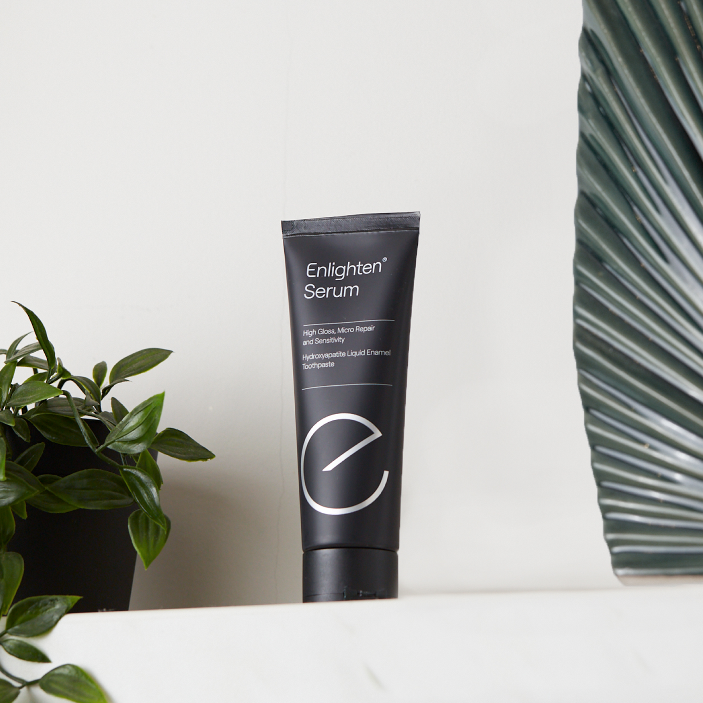 Enlighten Serum on a shelf with plants