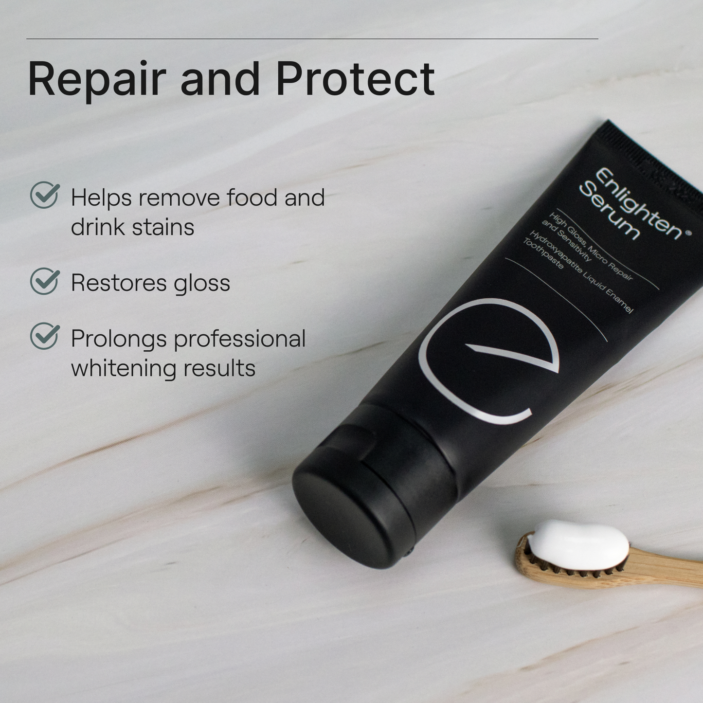 Enlighten Serum tube on marble surface with toothbrush, highlighting stain removal, gloss restoration, and prolonged whitening benefits