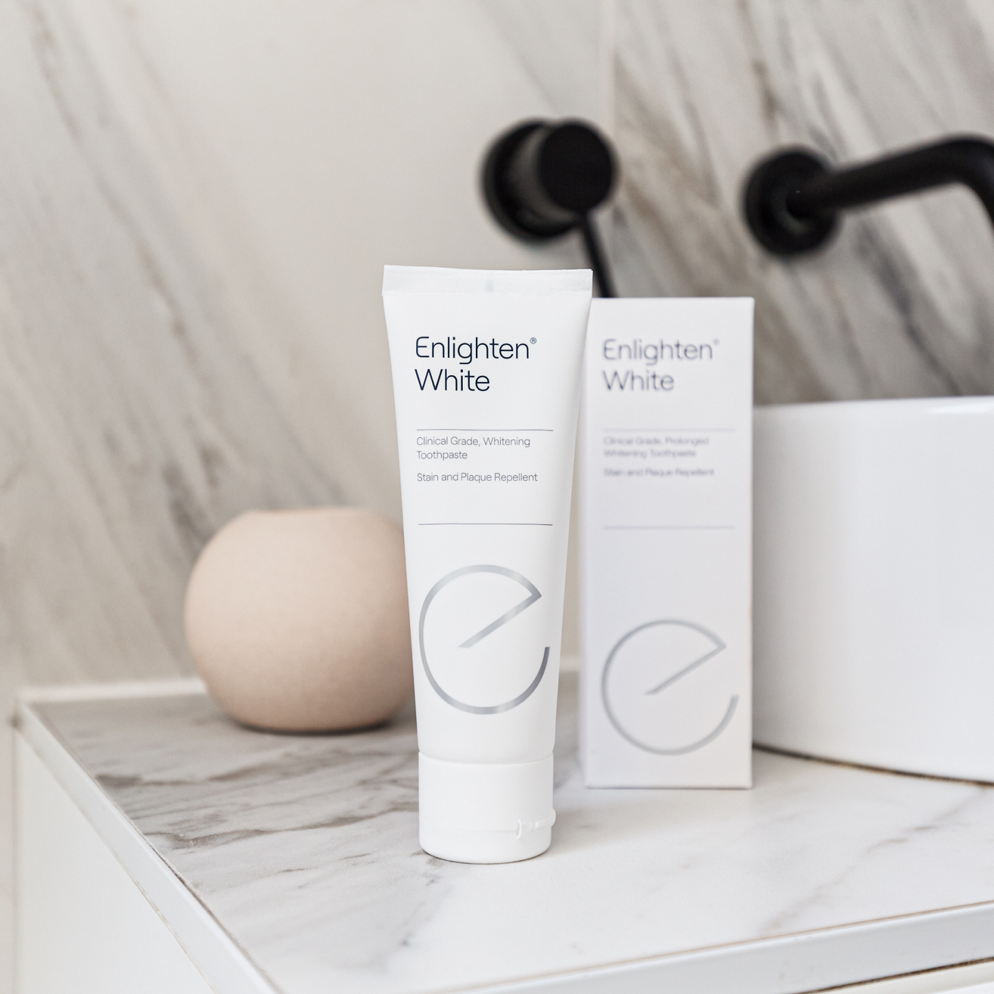 Enlighten White toothpaste tube and box on a bathroom counter
