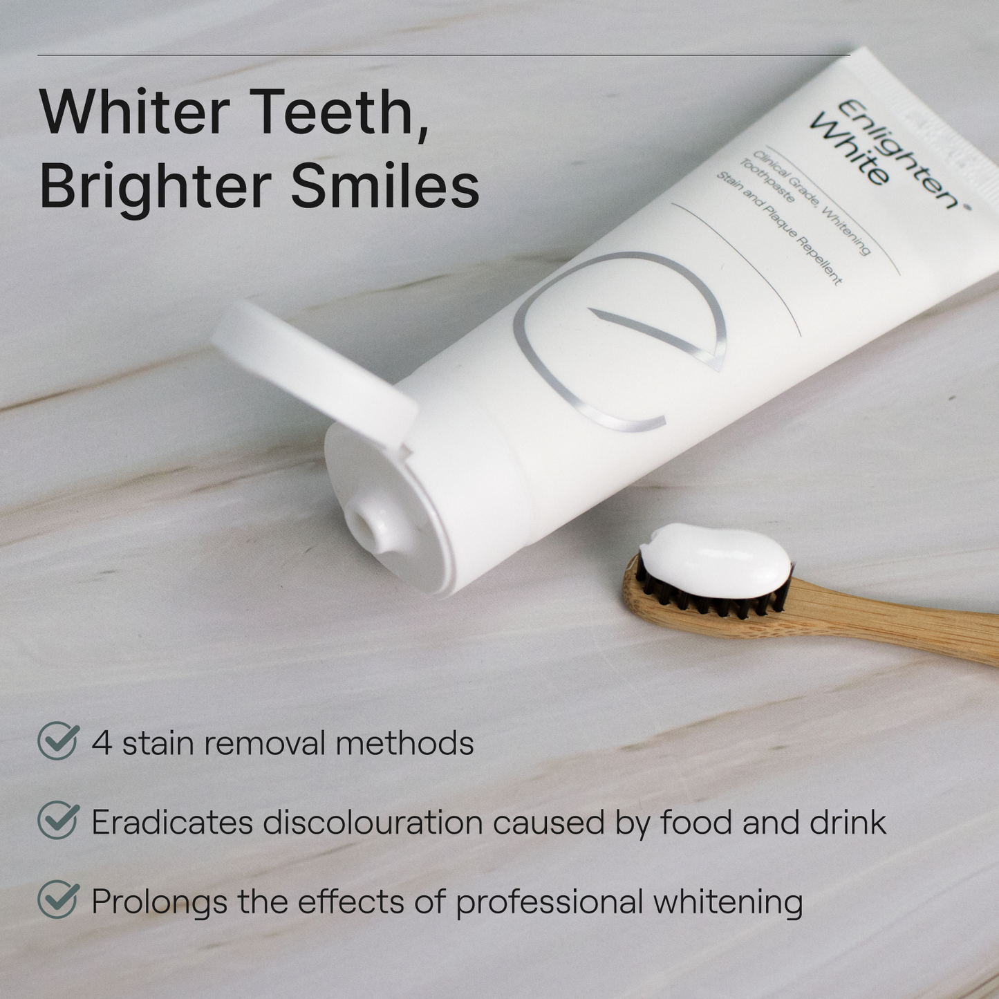 Enlighten Serum tube on marble surface with toothbrush, highlighting stain removal, gloss restoration, and prolonged whitening benefits
